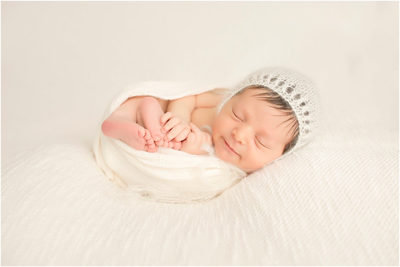 Newborn boy with cream hat
