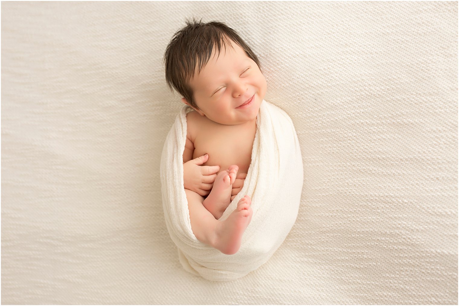 Newborn boy with big smile