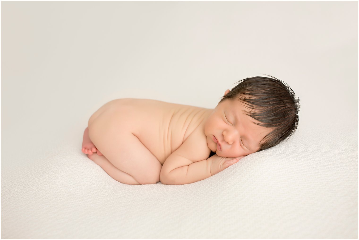 Newborn boy in tushie up pose