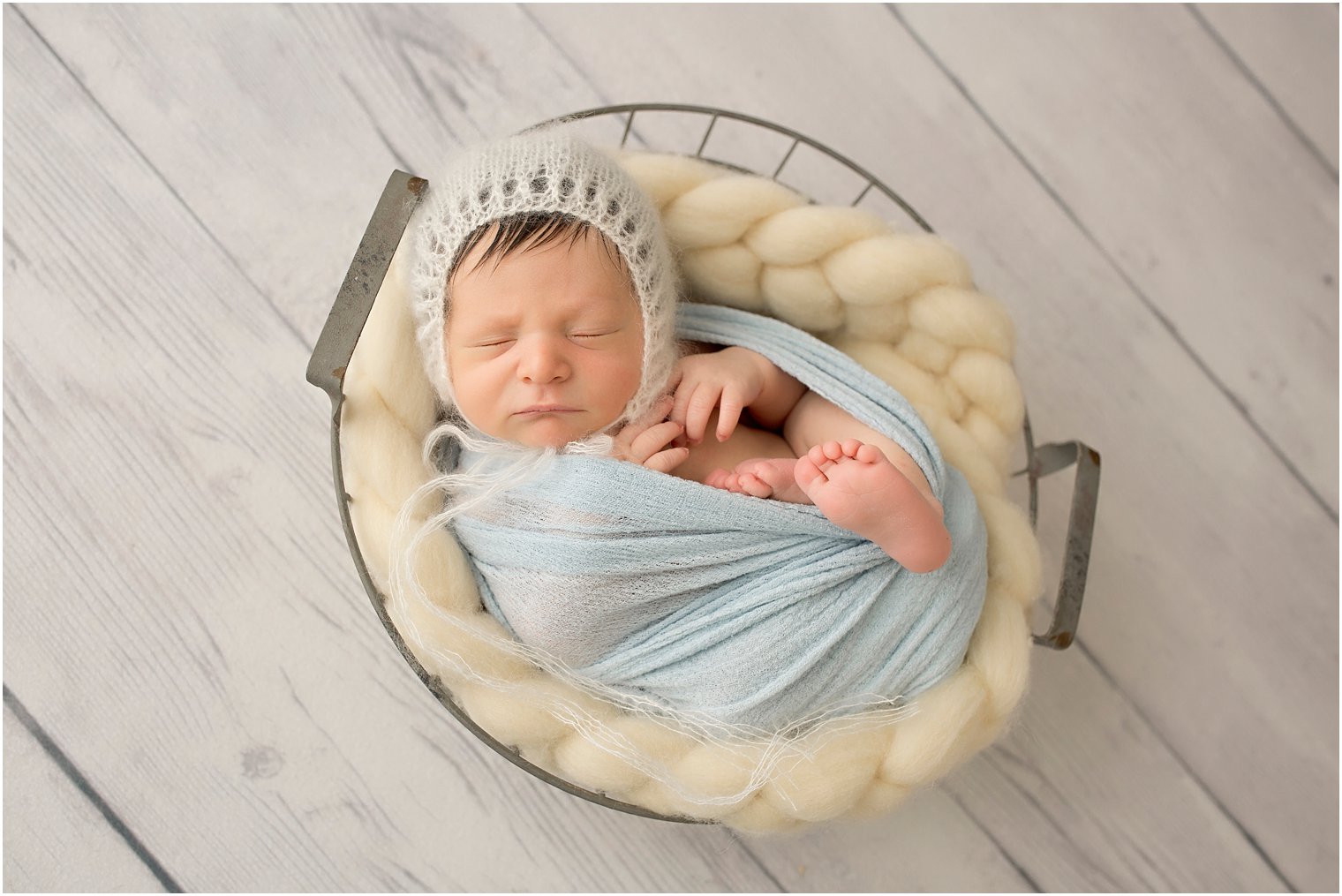 Newborn boy in bucket photo