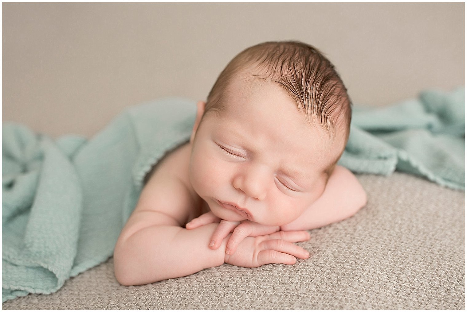Newborn boy with chin on hands | Photo by Idalia Photography