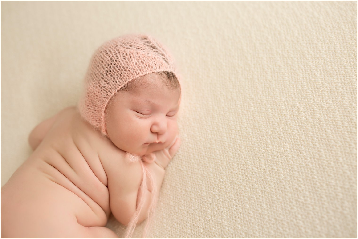 Newborn girl wearing peach hat by Blueberry Props