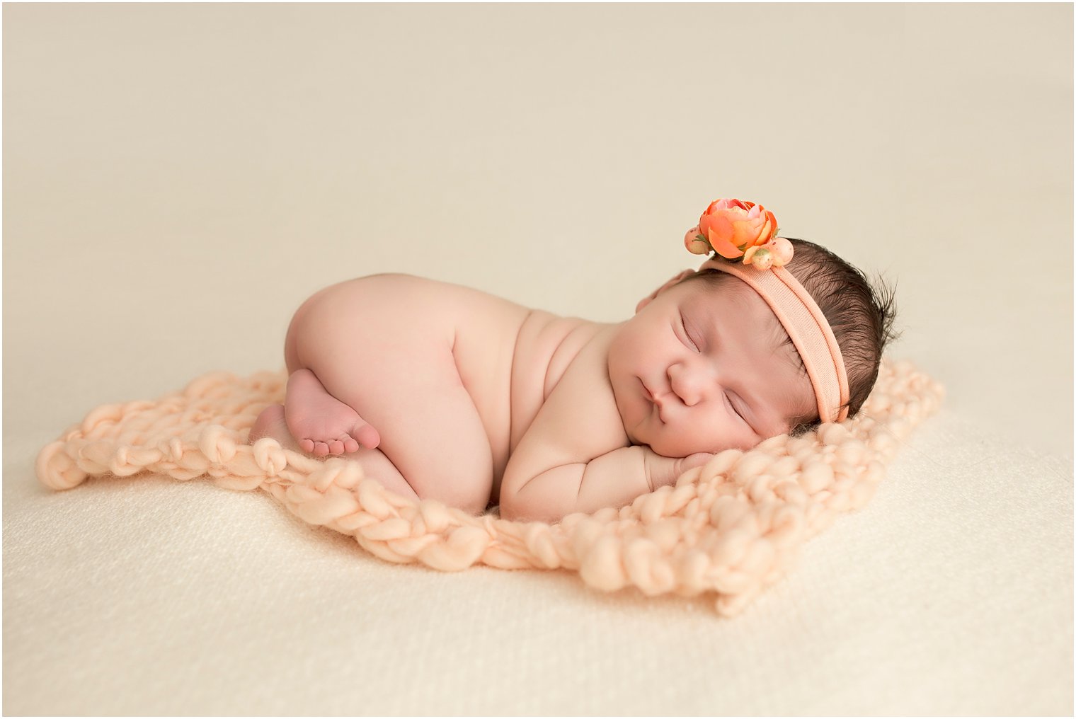 Newborn girl in peaches and cream