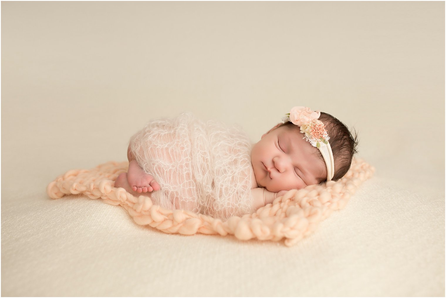 Newborn girl in ivory and peach