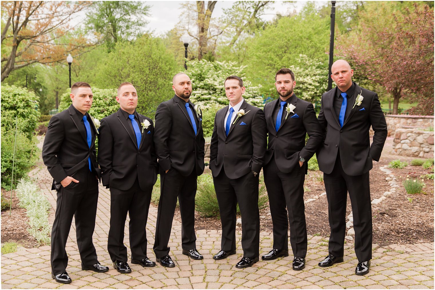 Groomsmen in black and blue suits from Men's Wearhouse