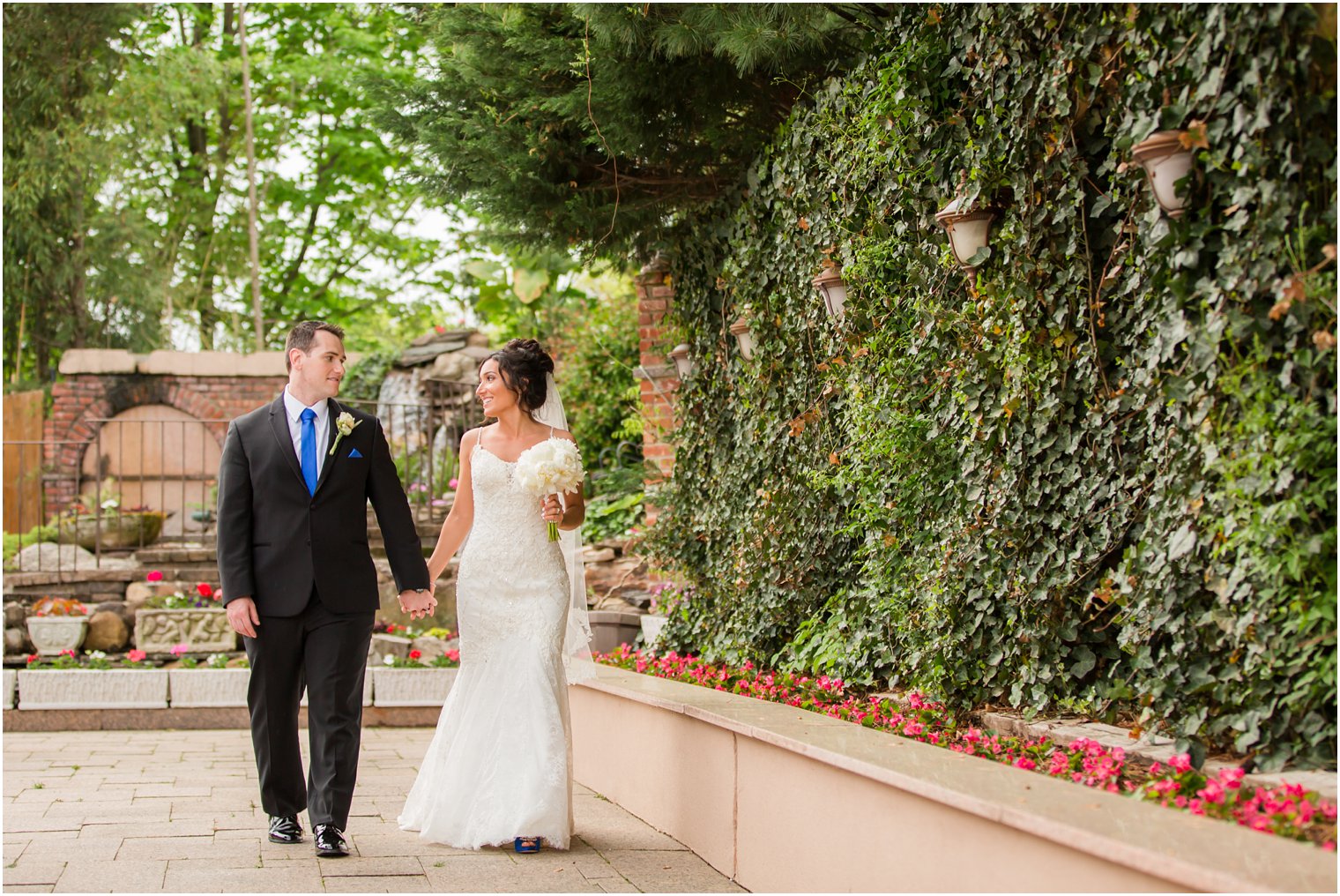 Bride and groom walking through garden