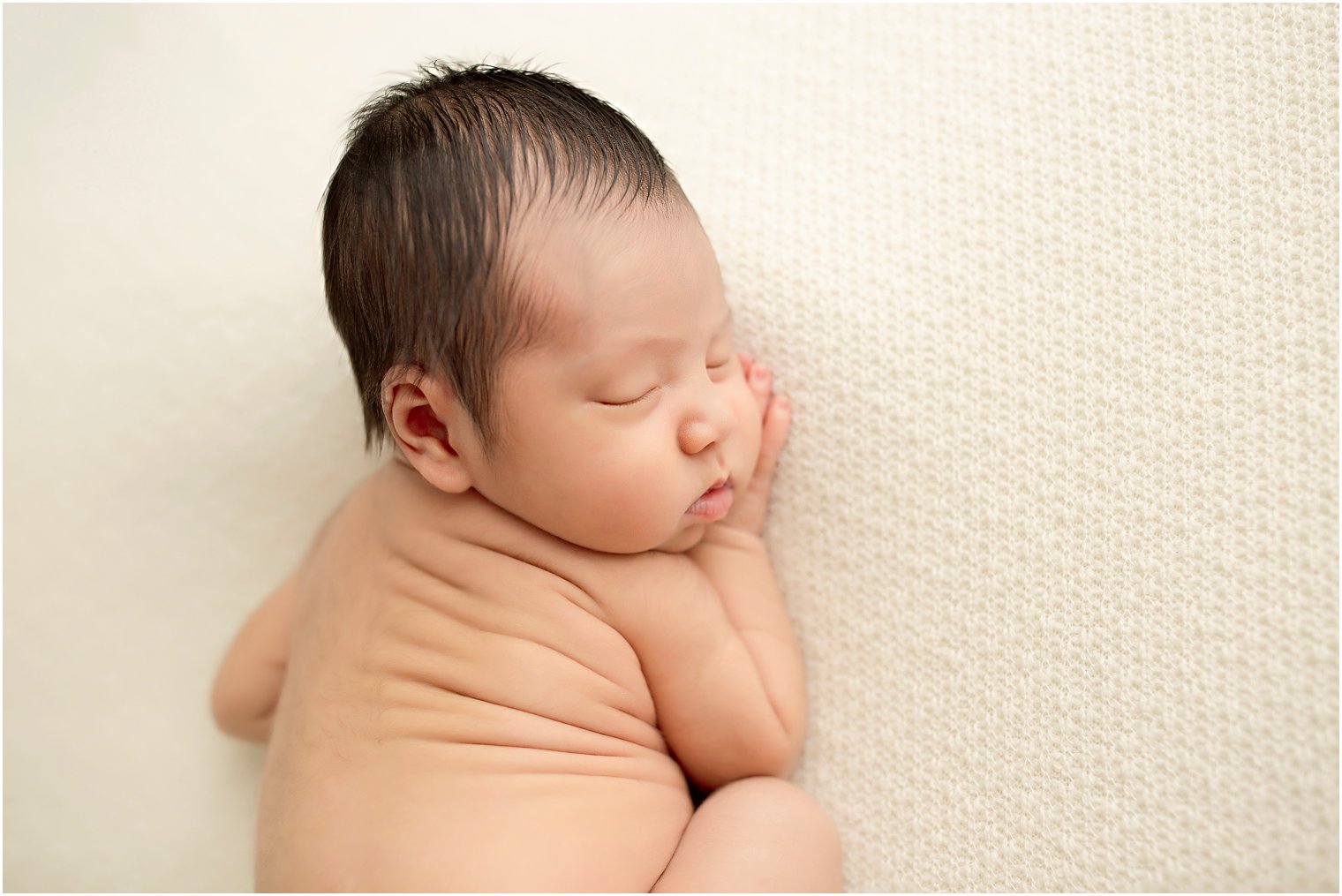 Newborn boy with cute back rolls