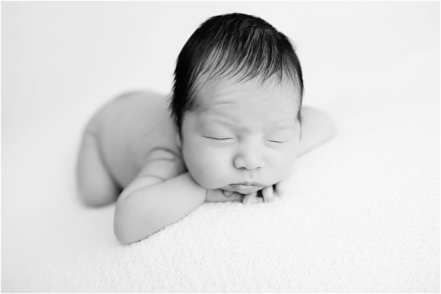 Newborn in chin on hands pose