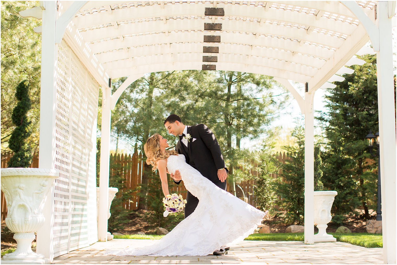 Groom dips bride under gazebo | Photos by Idalia Photography