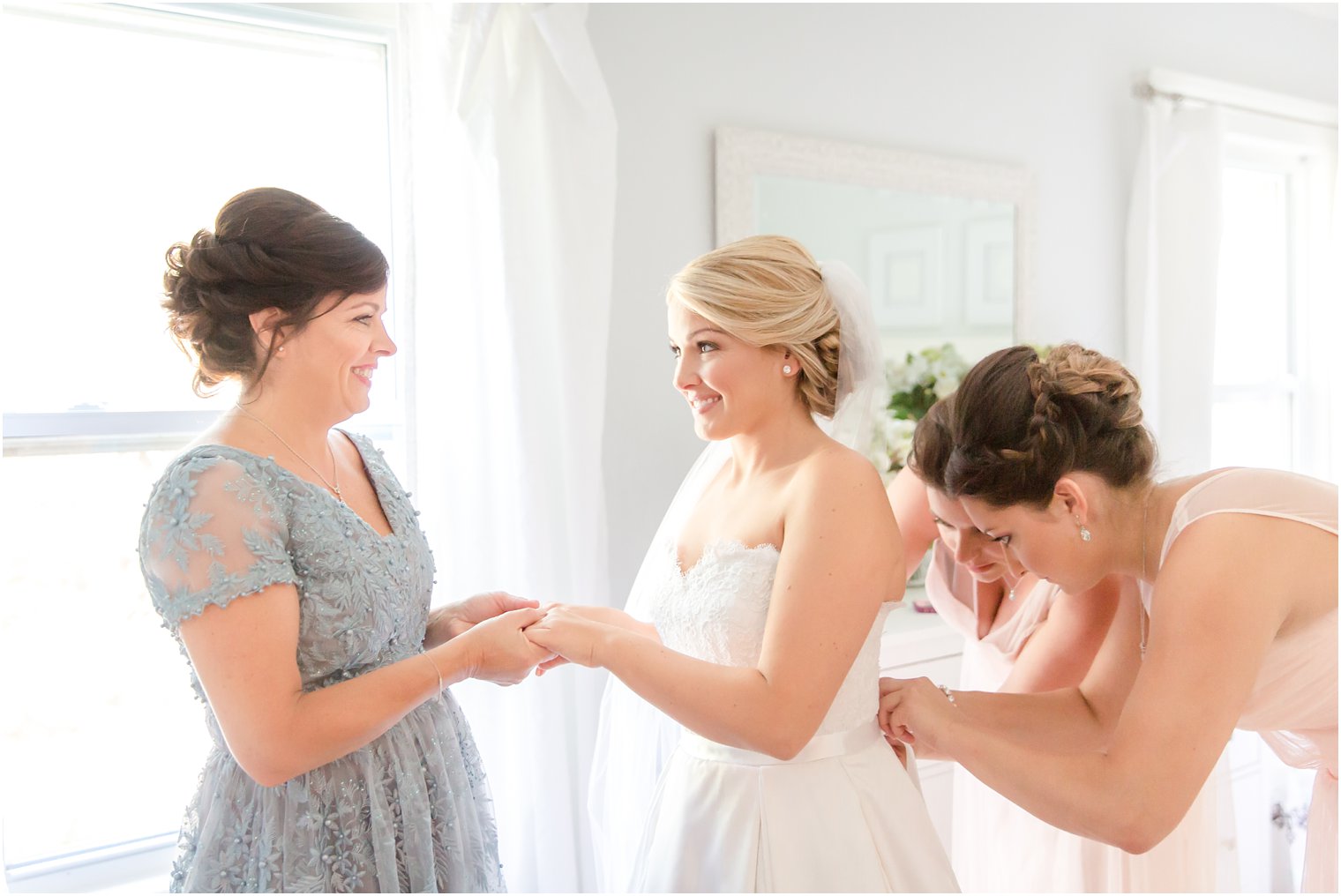 Bride getting ready with her mother and bridesmaids