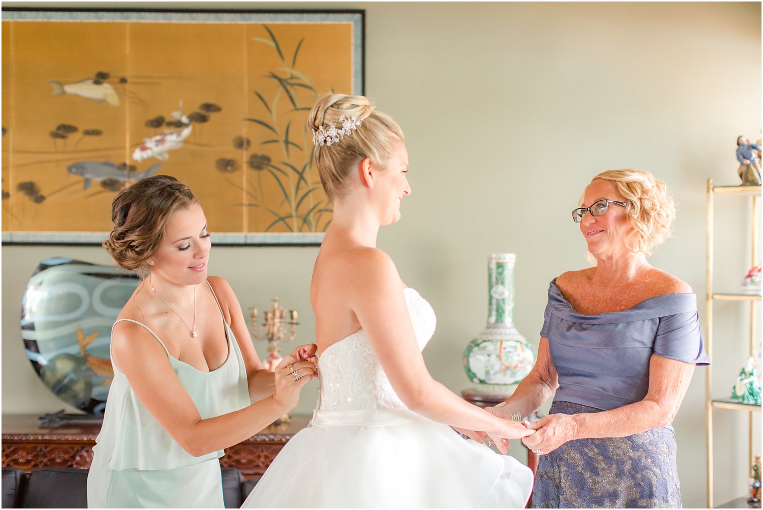 Bride getting ready with mother and maid of honor