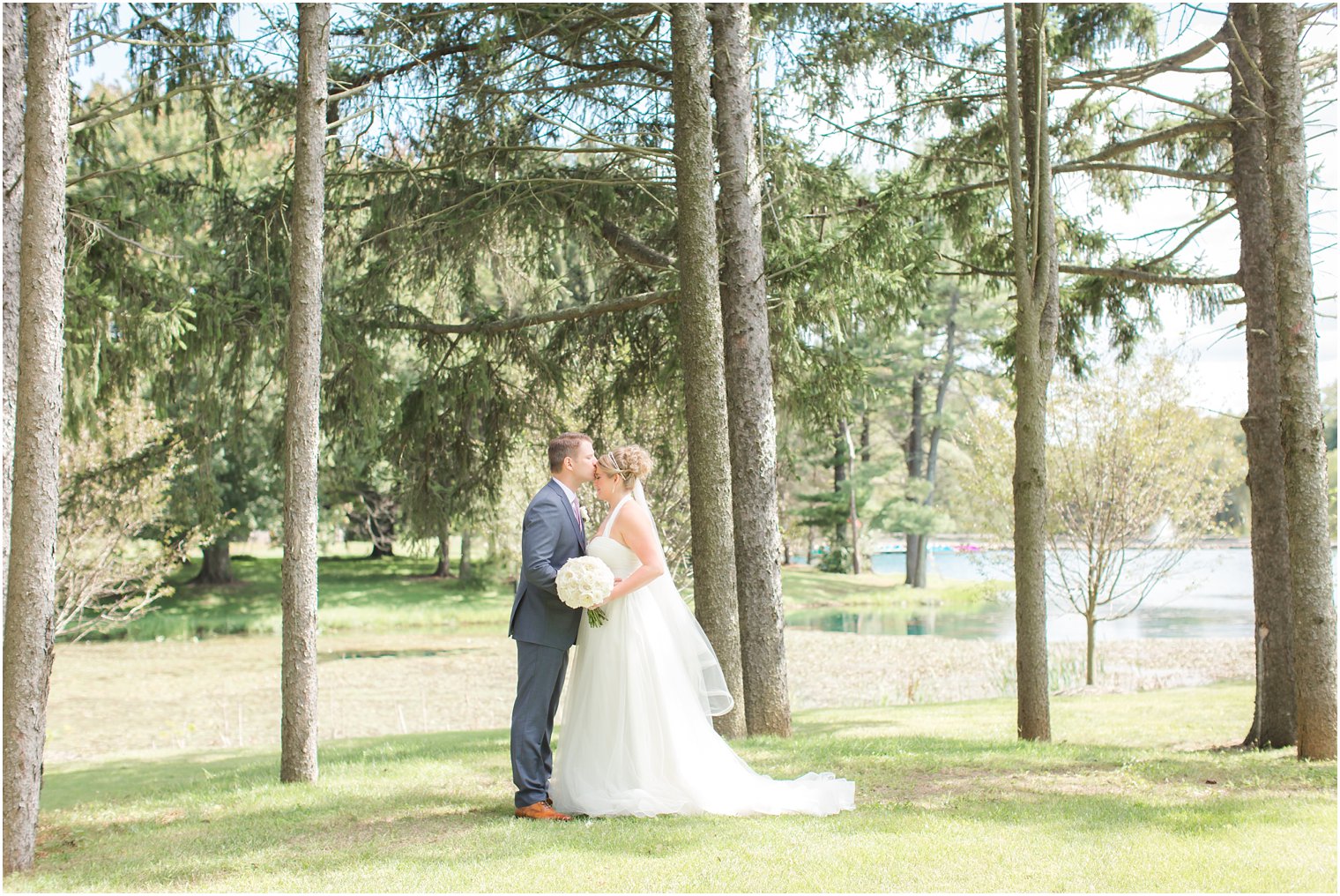 Groom kissing his bride on the forehead at Windows on the Water at Frogbridge Wedding