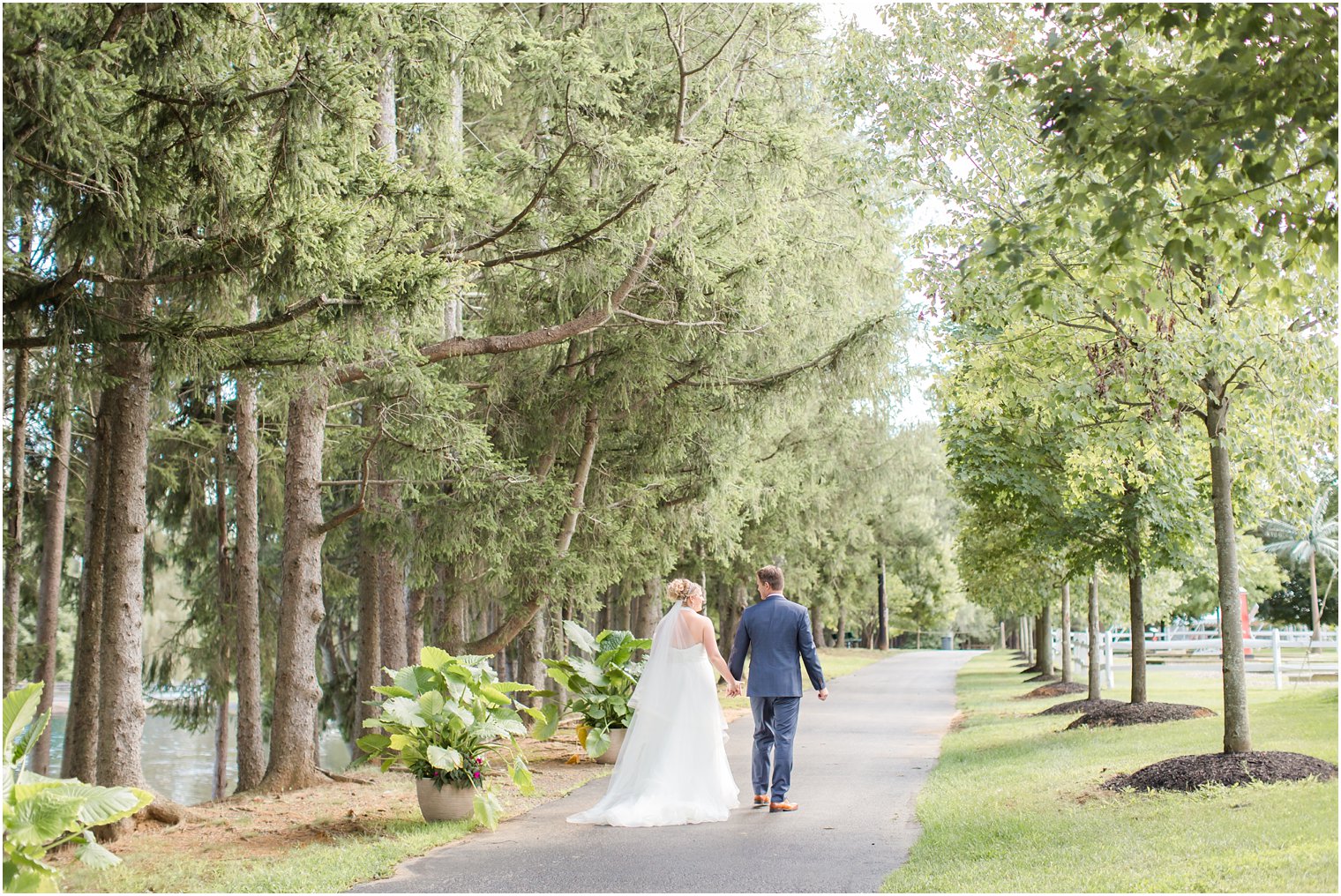 Bride and groom walking down a path at Windows on the Water at Frogbridge Wedding