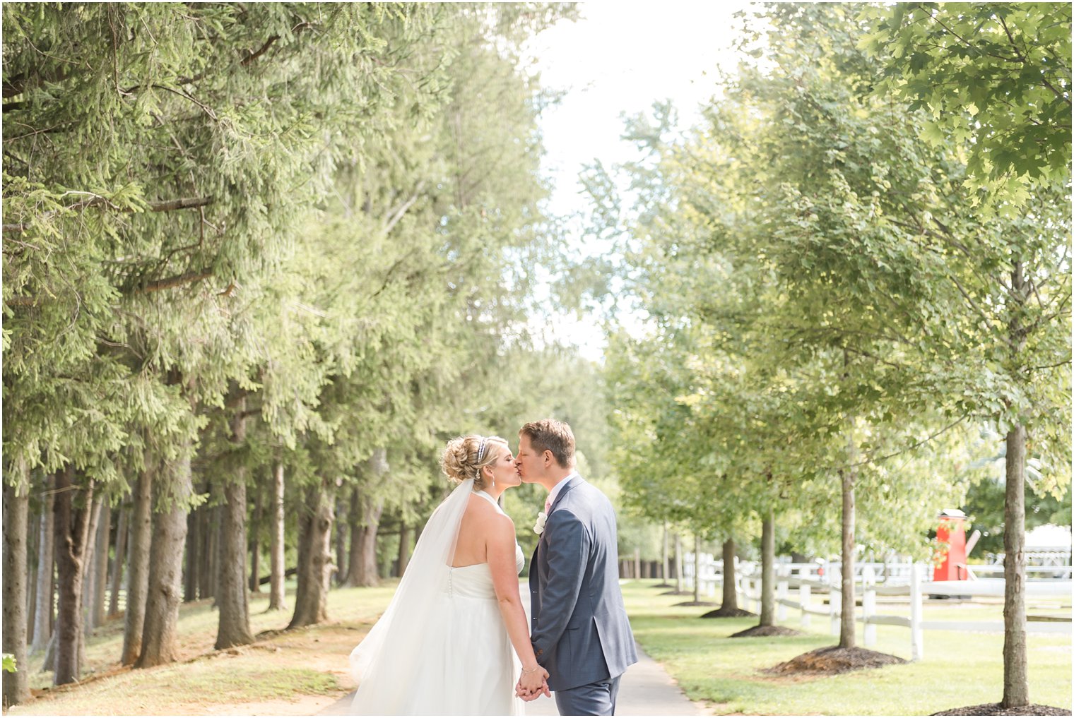 Bride and groom kissing down the path at Windows on the Water at Frogbridge Wedding