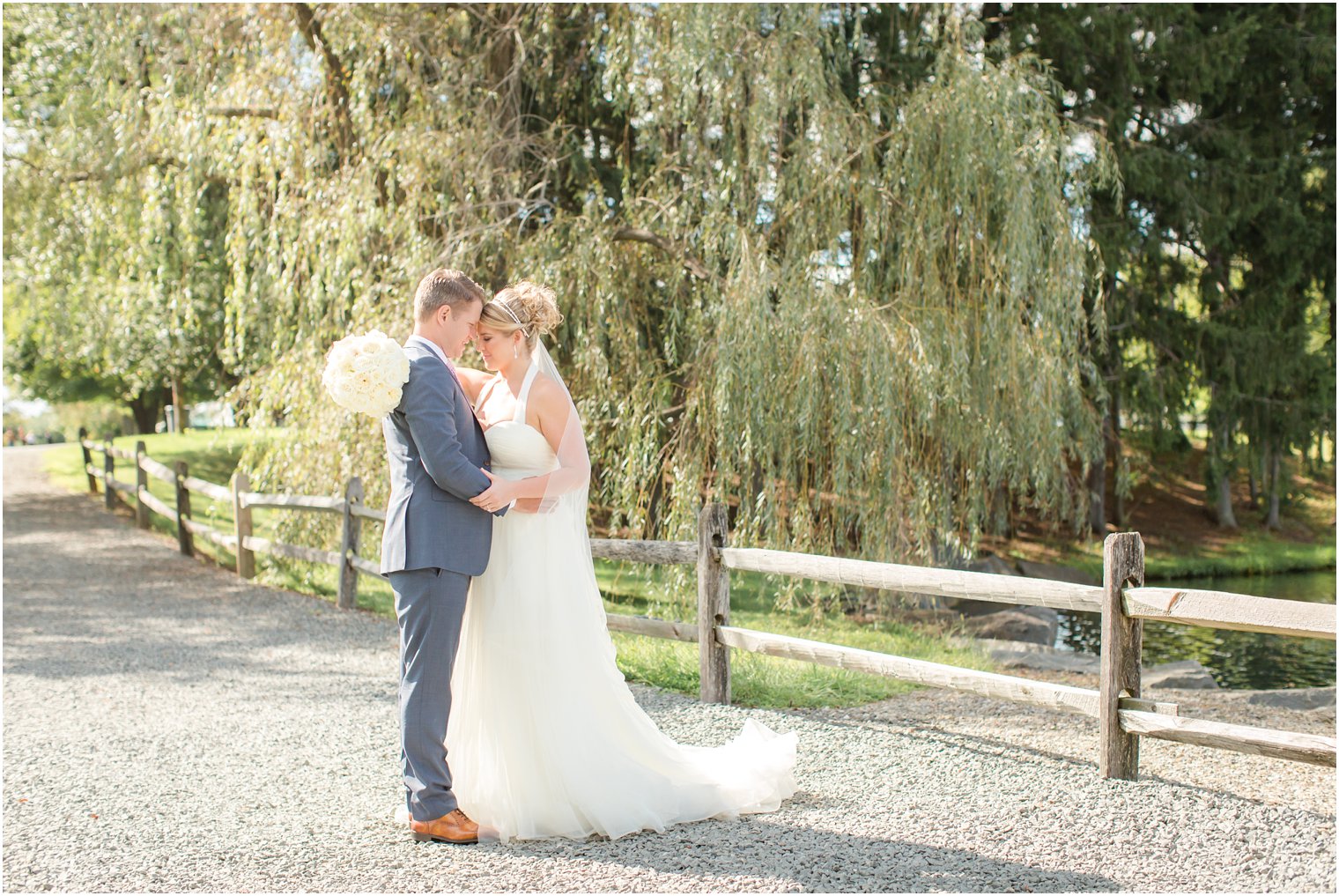 Romantic bride and groom portrait in front of willow tree at Windows on the Water at Frogbridge Wedding