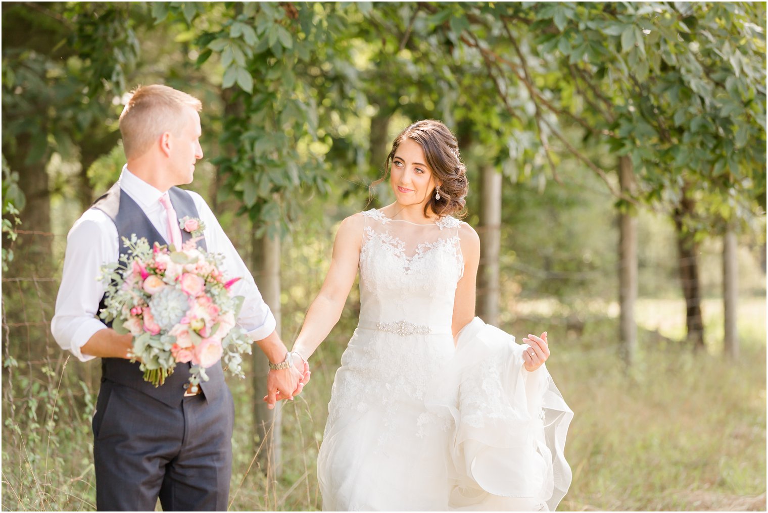 Bride and groom walking in field