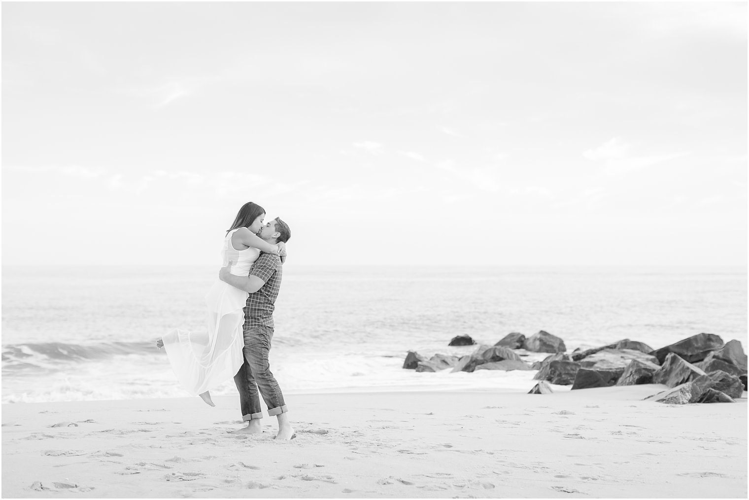 Man lifting fiance on the beach during a photo session