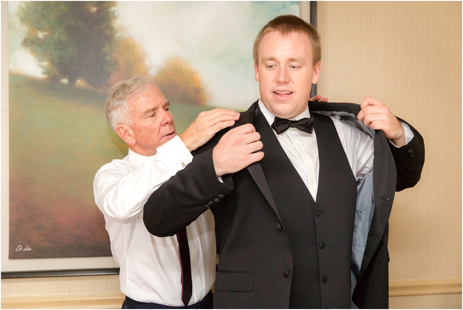 Groom getting ready with his father on his wedding day