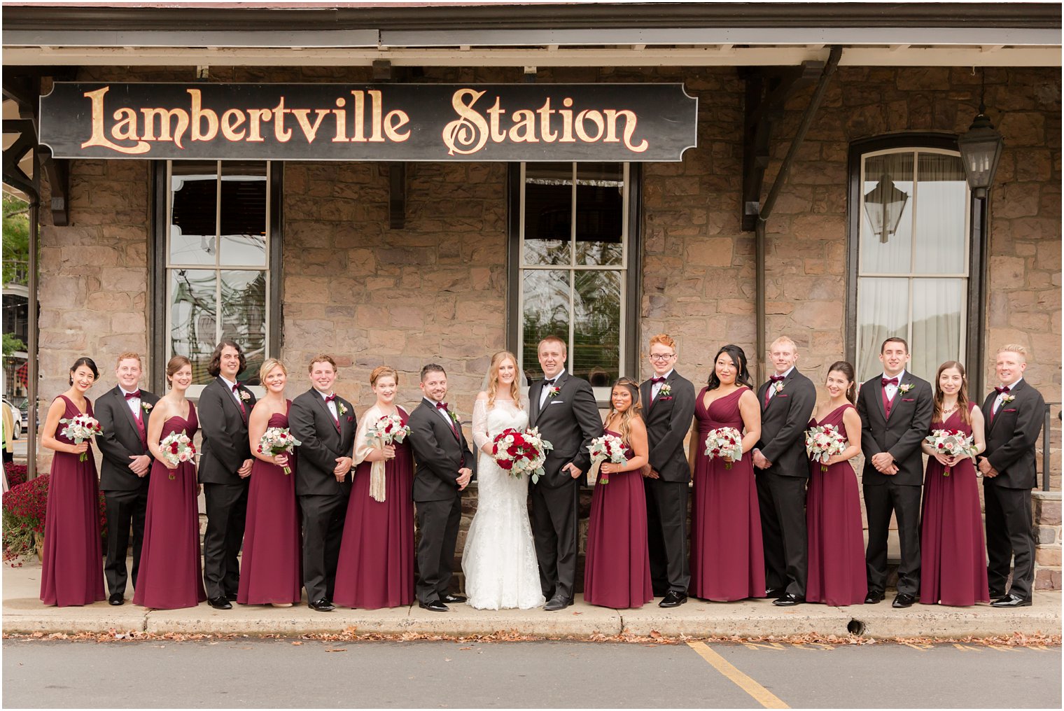 Bridal party in burgundy dresses and black tuxedos