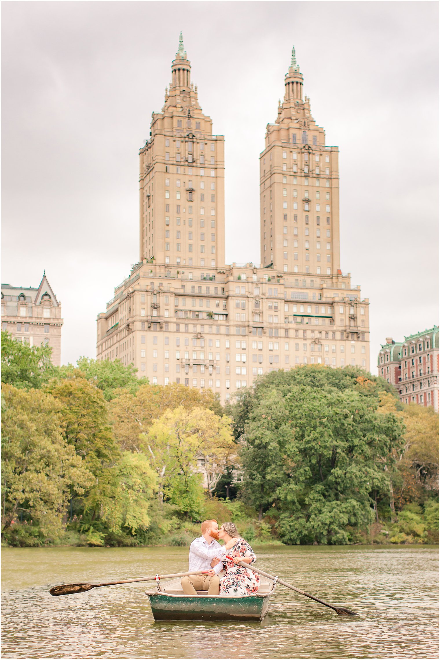 Engagement photo at lake in Central Park with couple on boat