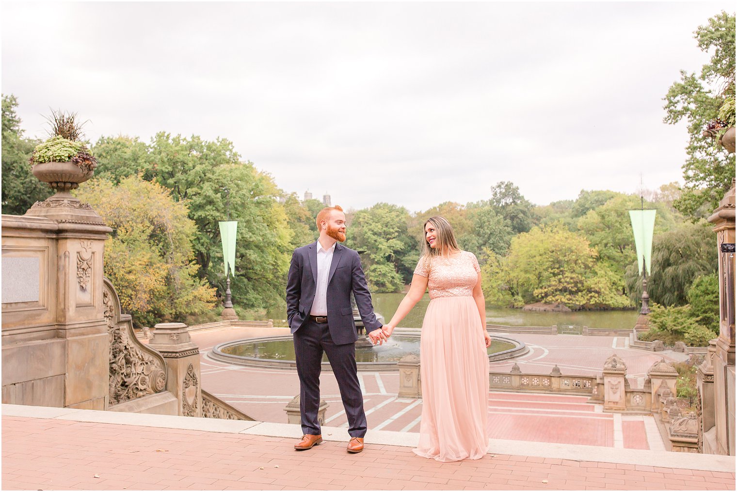 Engaged couple at Bethesda Terrace in Central Park with Bethesda Fountain in the background