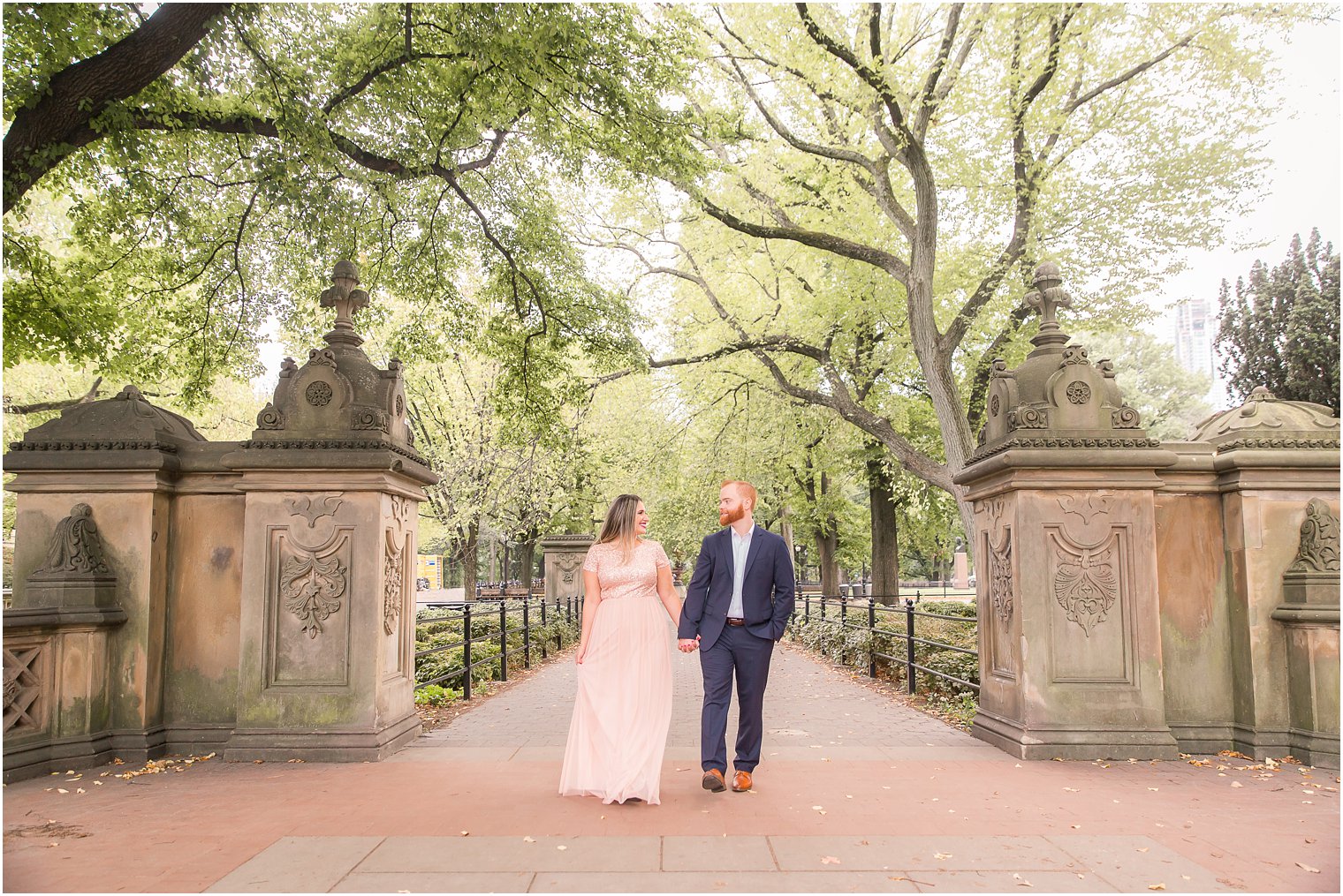 Engagement photo of couple walking in Central Park