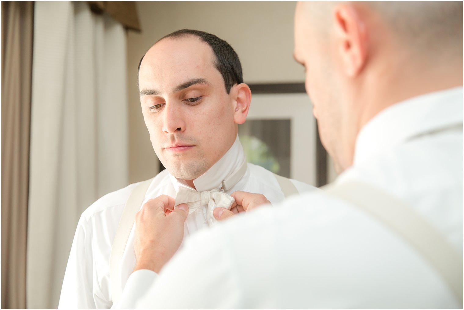 Groom wearing white bow tie on wedding day