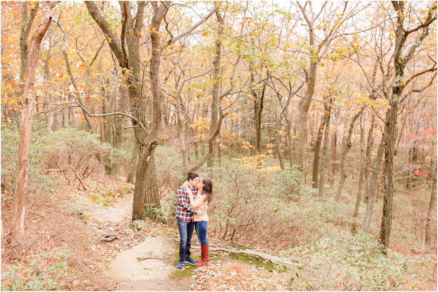 Couple kissing in the woods at Bear Mountain