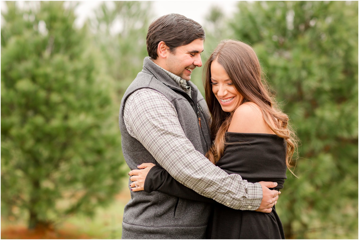 Candid engagement photo with bride and groom laughing