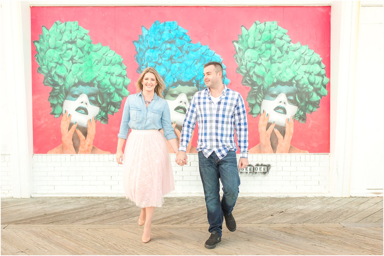Asbury Park engagement photo on the boardwalk with murals in the background
