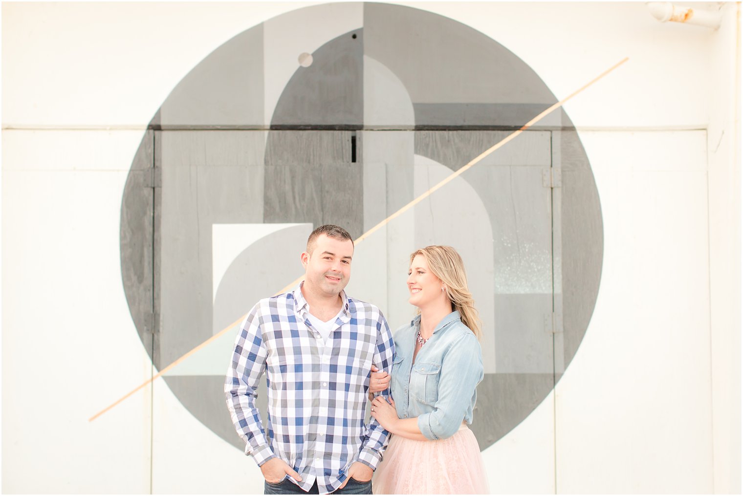 Engagement photo with murals in the background