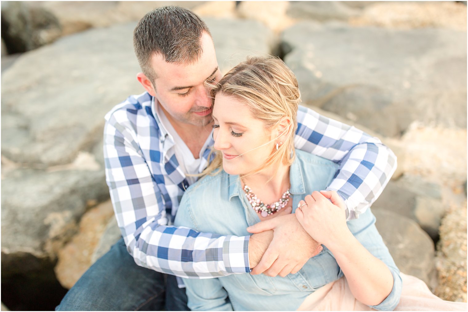 Bride and groom sitting on jetty near Asbury Park convention hall