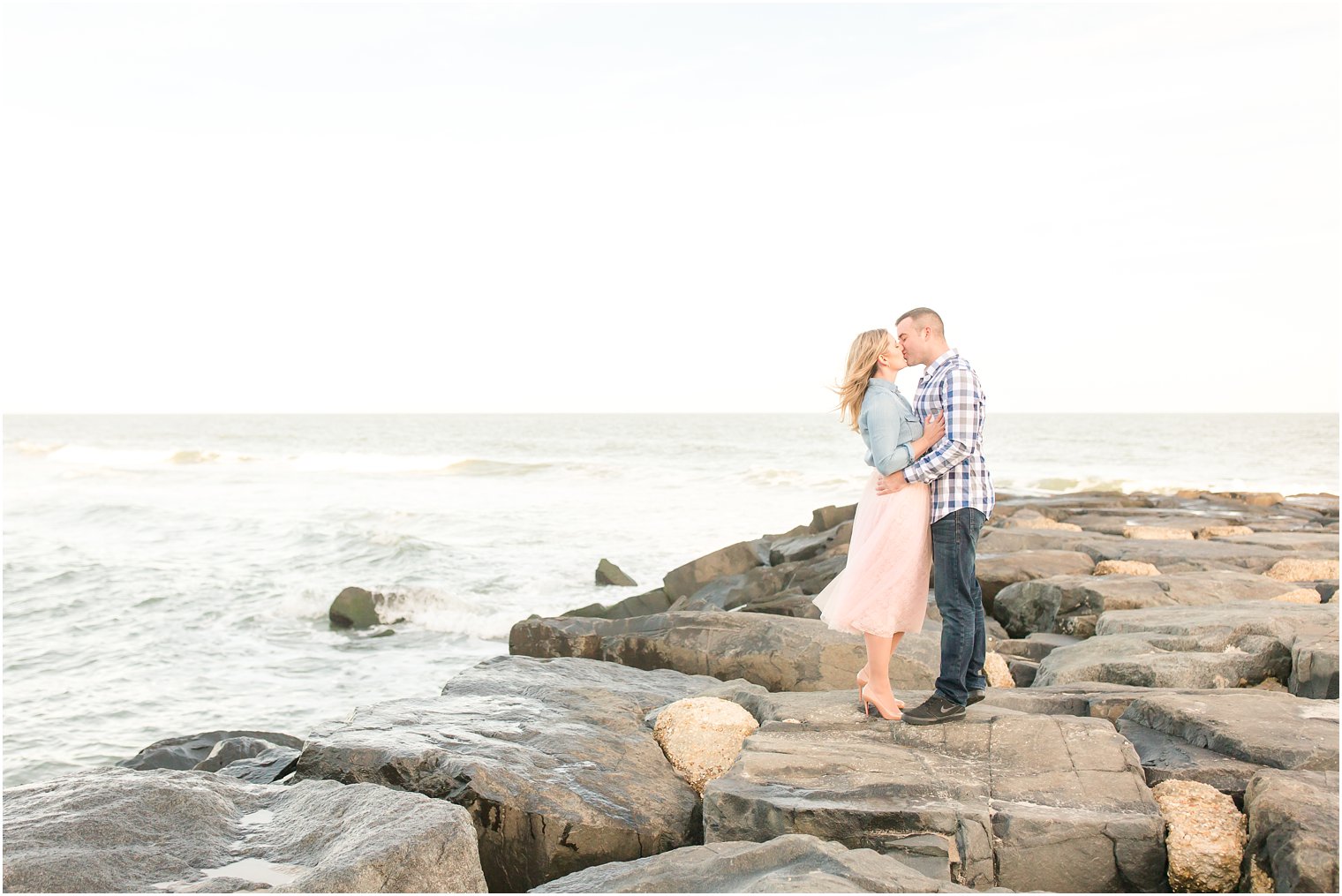Photo of bride and groom kissing on jetty in Asbury Park
