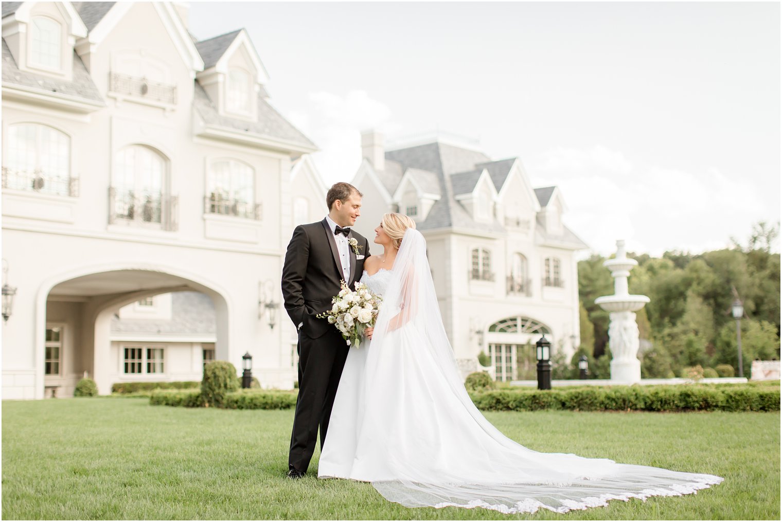 Bride and groom standing in front of Park Chateau Estate and Gardens