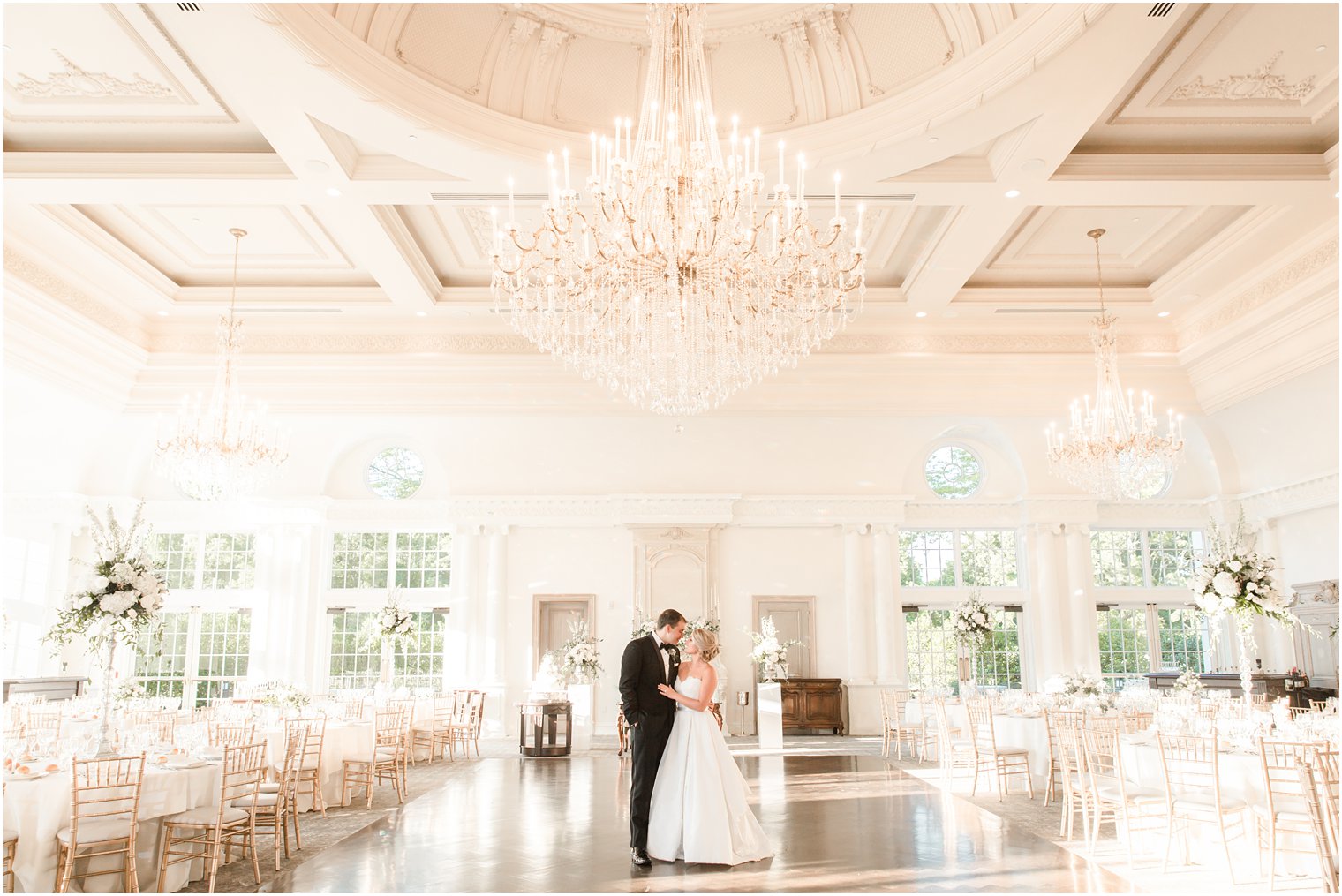 Bride and groom in empty ballroom