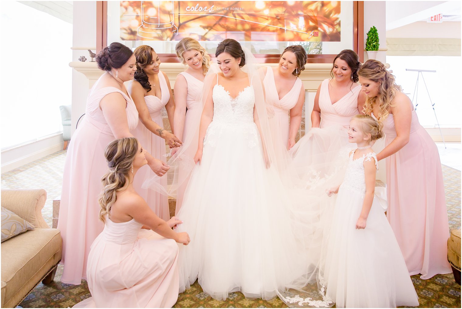 bridesmaids helping bride get dressed on wedding day