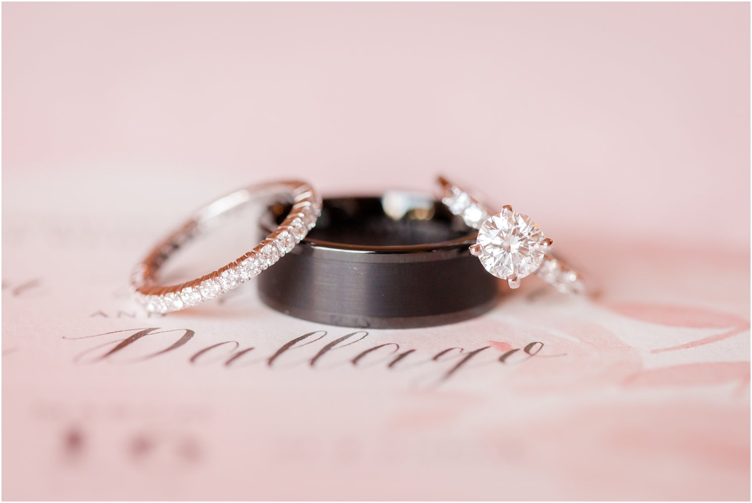 wedding rings on pink invitation