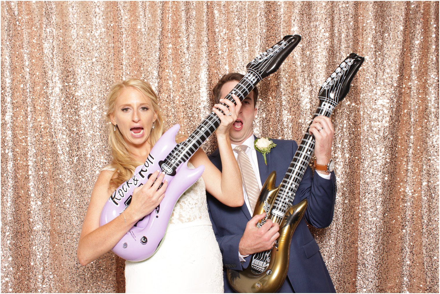 bride and groom with guitars in the photo booth