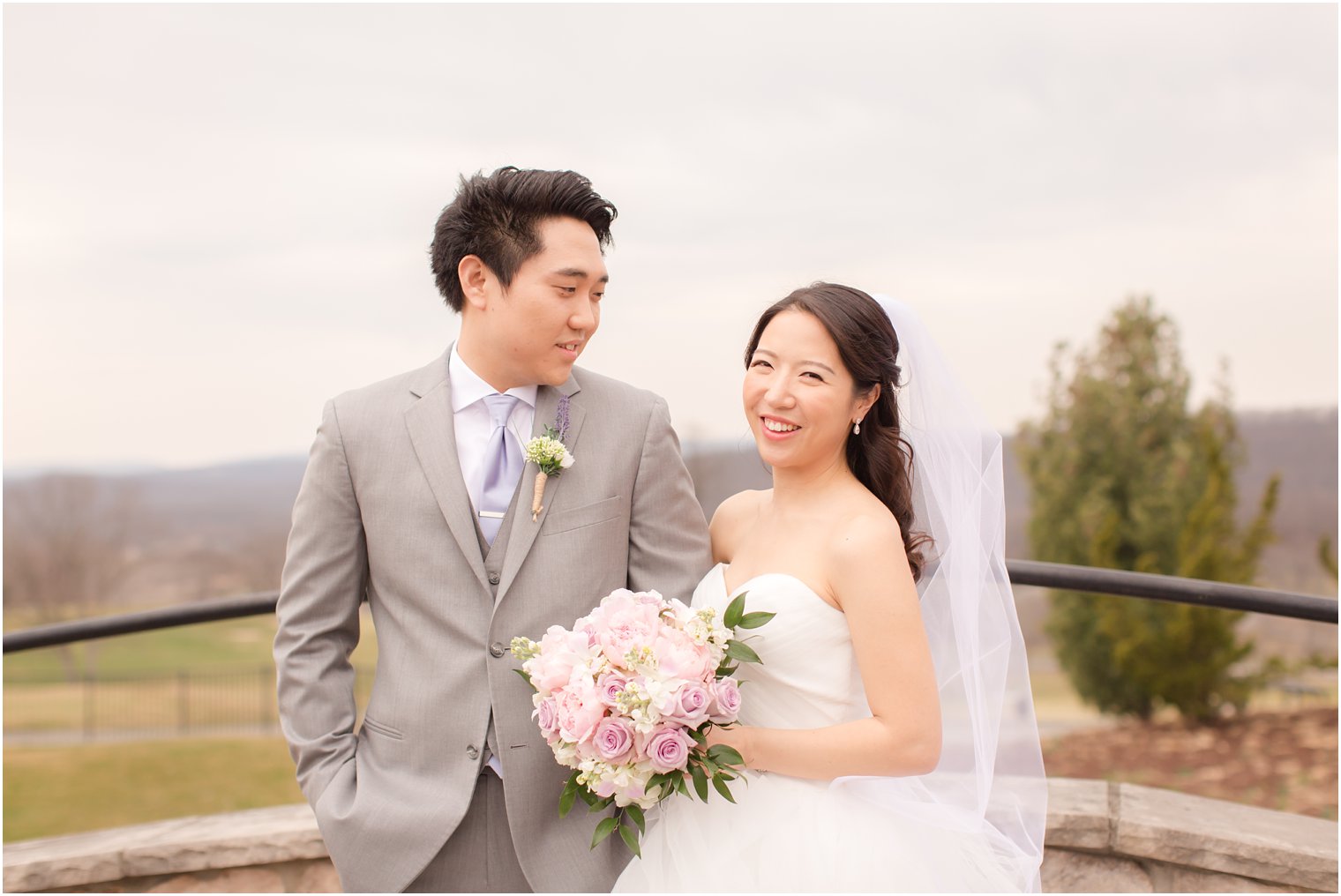 Happy bride on her wedding day standing next to groom