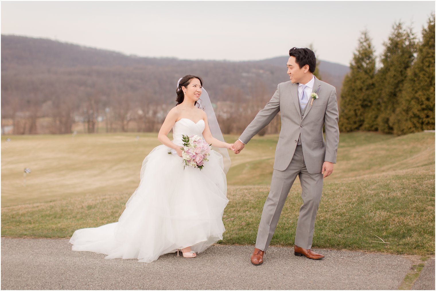 Bride and groom walking by golf course