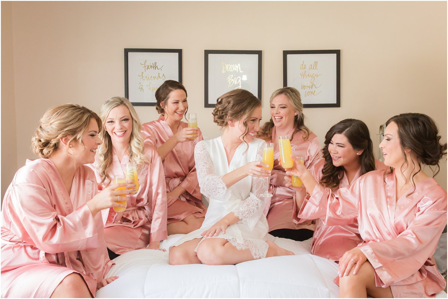 bride toasting with bridesmaids on bed