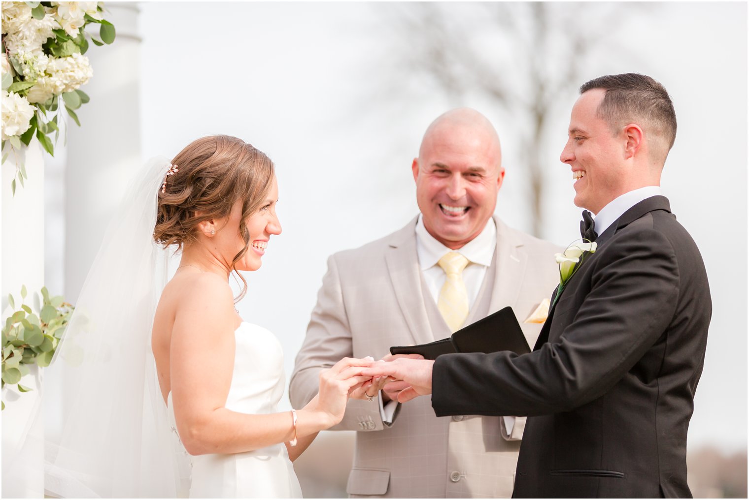bride and groom exchanging rings at outdoor ceremony at Pen Ryn Mansion