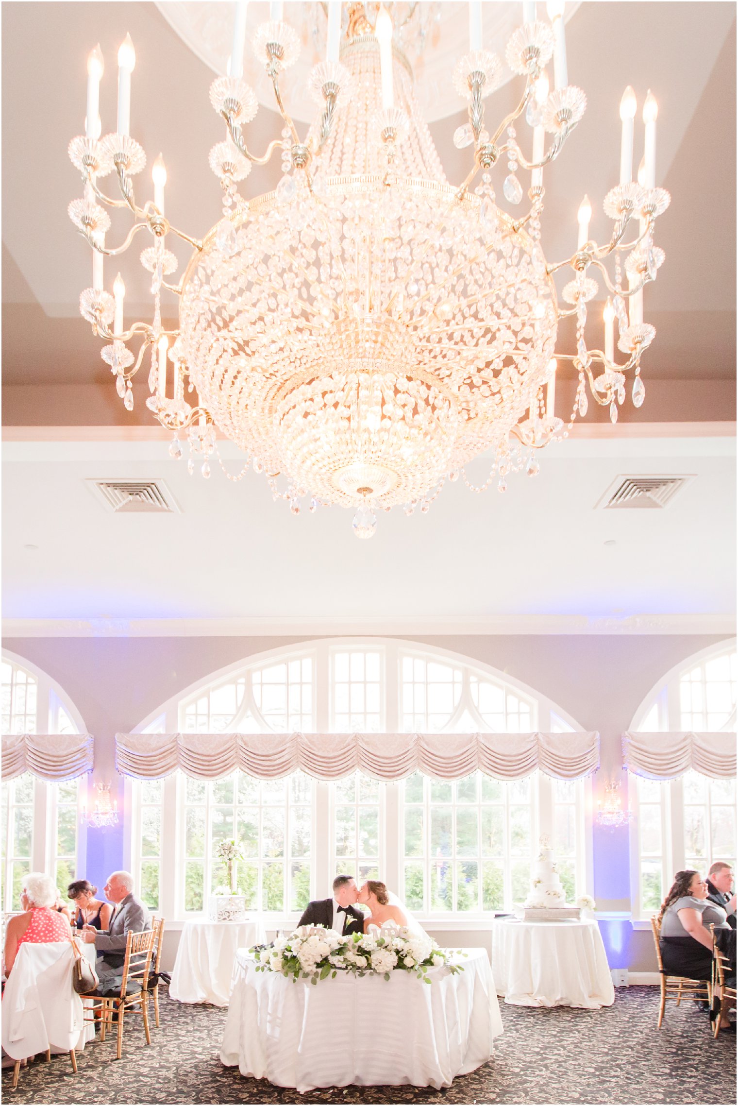 bride and groom kissing at sweetheart table