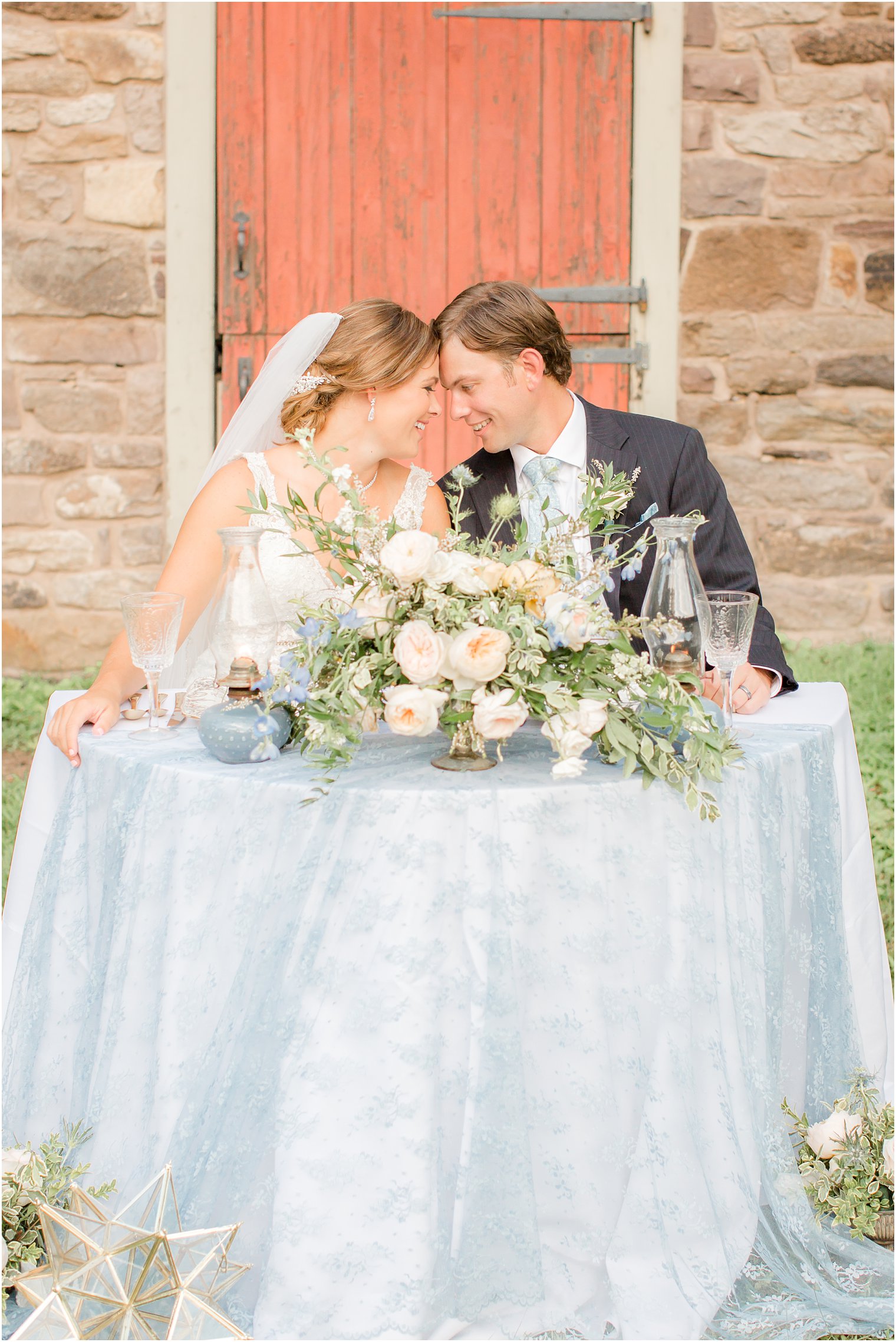 bride and groom at peach and dusty blue inspired sweetheart table photographed by Idalia Photography