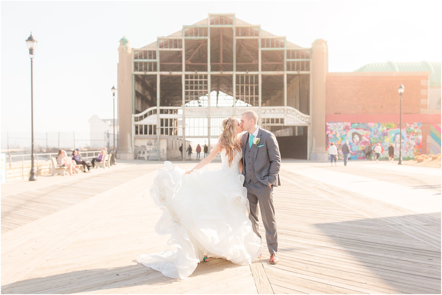 Bride and groom kissing on the boardwalk in Asbury Park