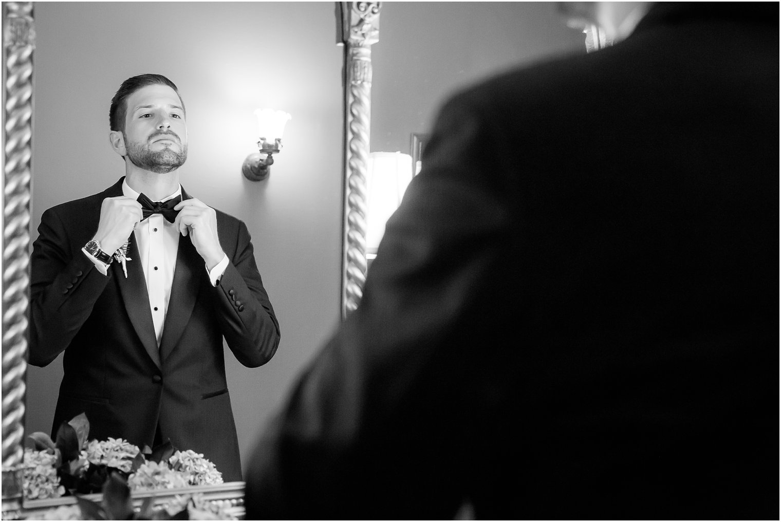 Groom putting on a black tie