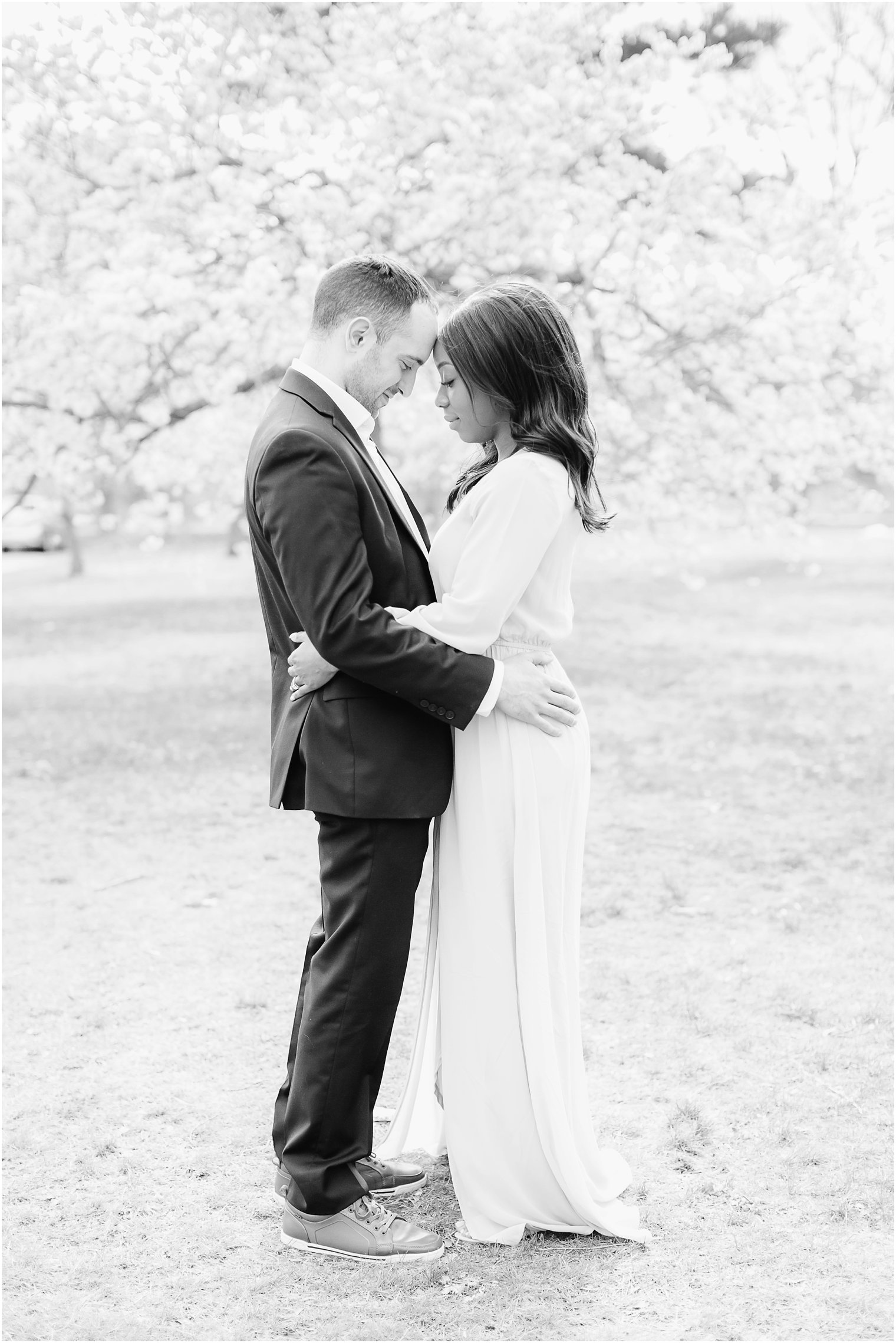 black and white photo of engaged couple in cherry blossoms