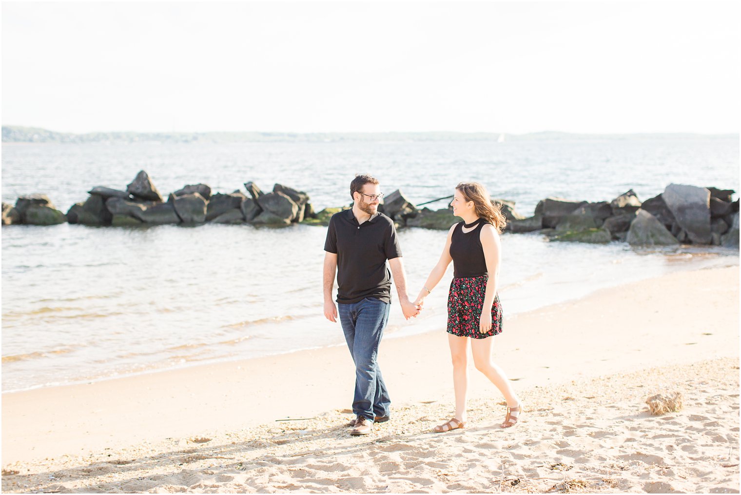engaged couple walking on the beach