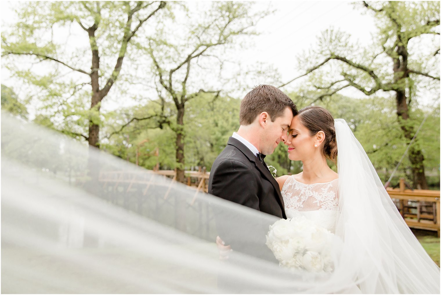 Bride and groom in a swooping veil photo