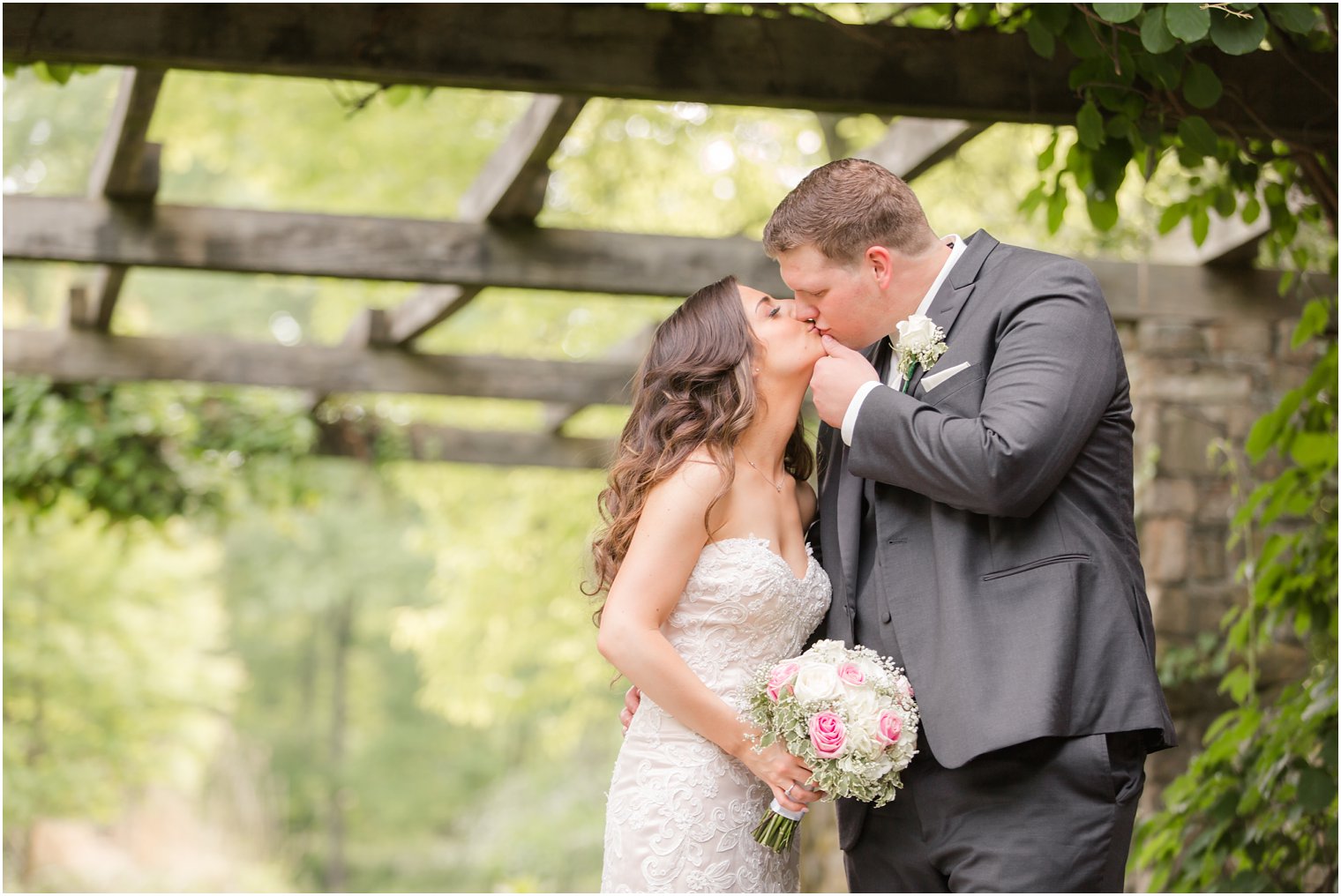 bride and groom kissing under the pergola
